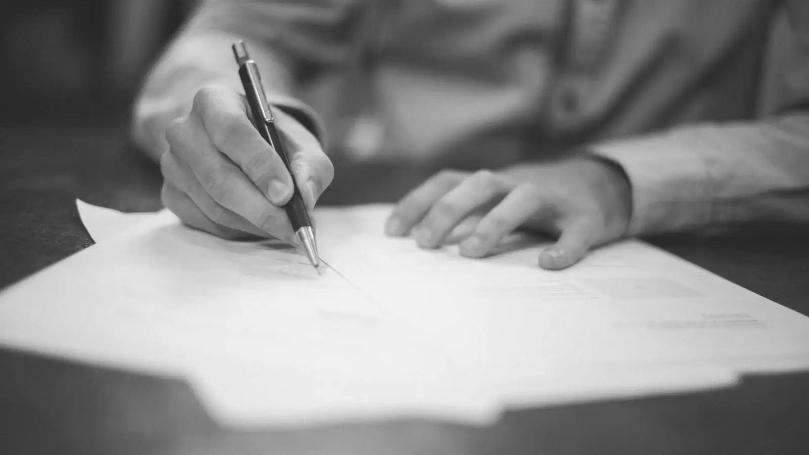 Signature d'un document contractuel au stylo